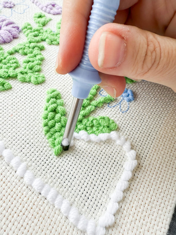 Punching yarn with a punch needle